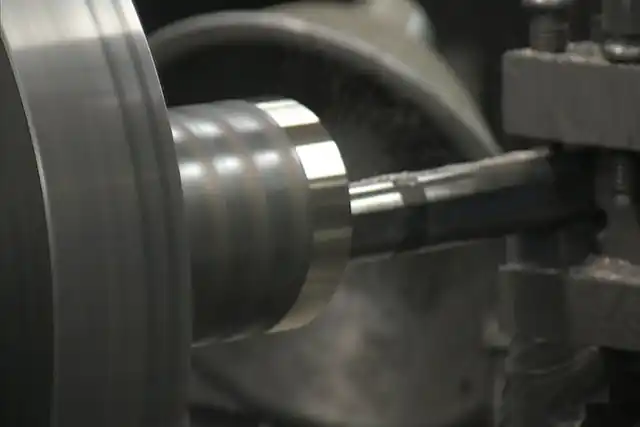 Close-up of the lathe cutting a pump shaft