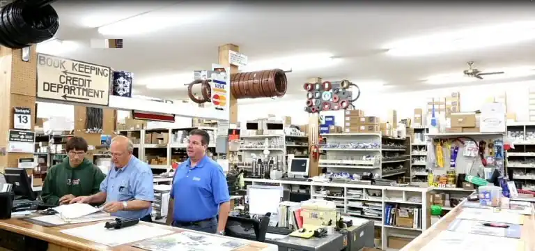 Three Akland staff behind the parts counter in the supply store